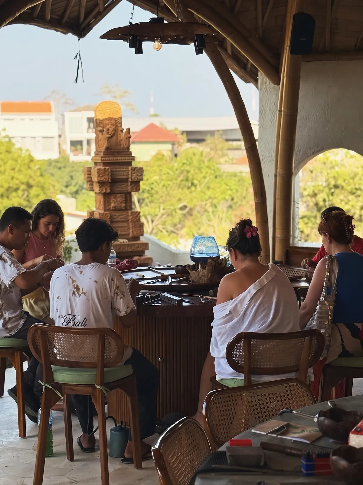Guests at the round benches of the open-air gallery, around the carved guardian pillar